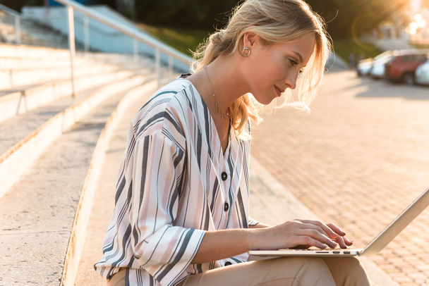 Прекрасна молода блондинка використовує ноутбук
 - Фото, зображення