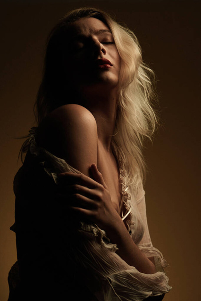 Art fashion portrait of sexy sensual young blonde woman with red lips and topless. Conceptual artistic photo of posing beautiful model in dramatic subdued light - Fotoğraf, Görsel