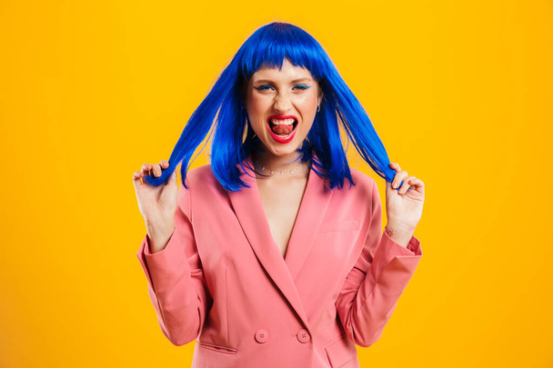 Portrait of attractive cute woman wearing blue wig looking and grimacing and camera - Fotografie, Obrázek