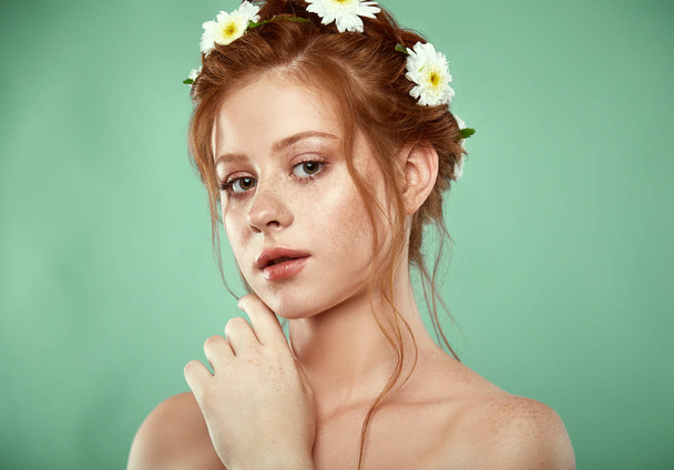 Beautiful positive redheaded girl with a chamomile crown on her head - Fotografie, Obrázek