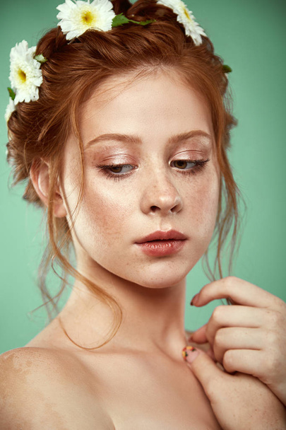 Beautiful positive redheaded girl with a chamomile crown on her head - Φωτογραφία, εικόνα