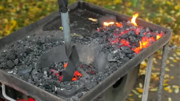Krijgers openen draagbare oven. Het verbranden van kolen in de oven, het blussen van vuur in de oven in smederij tijdelijke werkplaats. Concept van backsmithing - Video
