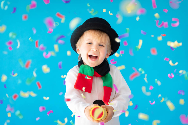Happy child wearing snowman holding party popper - Foto, Imagem
