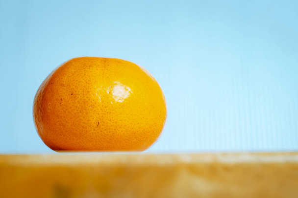 Orange 1 ball laid on the table, blue background - Fotó, kép