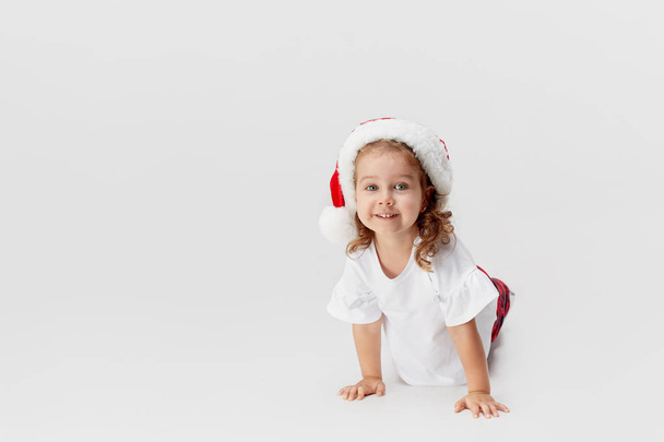 Portrait of little child girl in Santa hat having fun isolated on white background. Christmas and new year concept. - Foto, Imagem