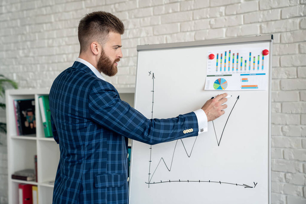 Businessman making a presentation at office. Entrepreneur using whiteboard to present ideas for business planning and decision making. - Photo, Image