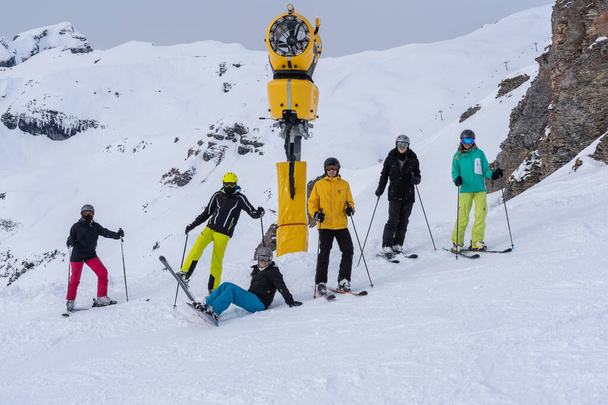 Молодые люди зимой, стоят в очереди на склоне в лыжах, сноуборд в облачный день
. - Фото, изображение