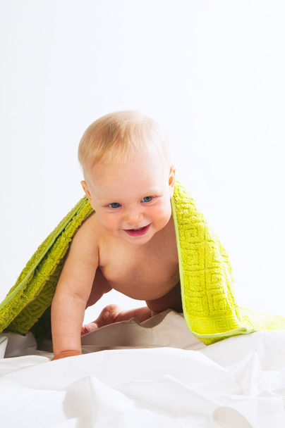 Happy baby girl under yellow towel - Foto, imagen