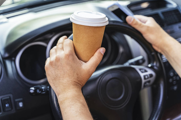 Man driving his car and drinking coffee - Foto, afbeelding