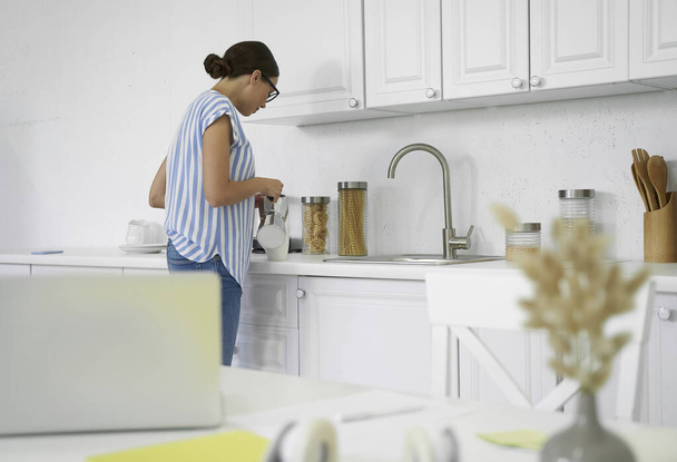 Woman pouring coffee from the coffee pot stock photo - Photo, image