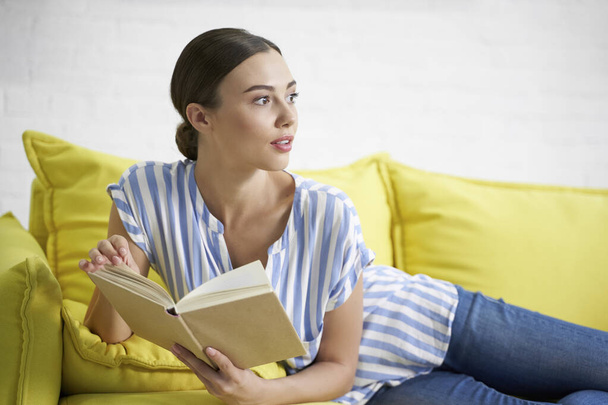 Woman with book looking away stock photo - Foto, Imagen