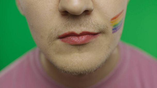 Parrakas mies, jolla on maalatut huulet hymyilemässä kameralle. HLBT:n yhteisö. Transseksuaalit
 - Valokuva, kuva