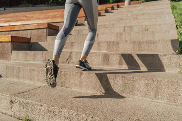 Close up of sportive lady running up on steps - Фото, изображение