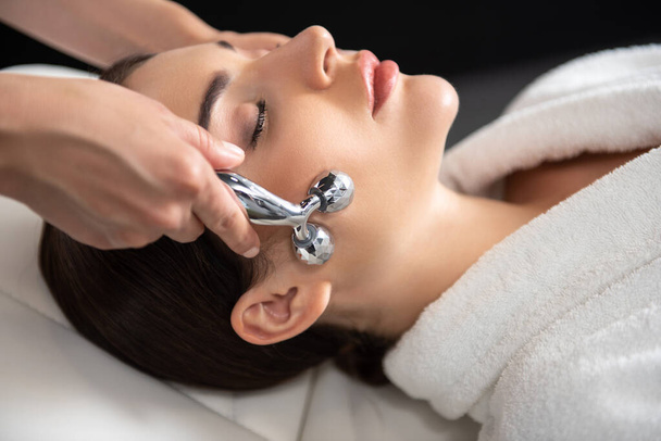 Masérka používající platinový masážní válec během lázeňské léčby - Fotografie, Obrázek