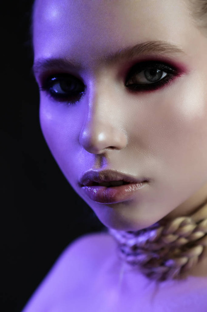 Close up studio portrait of beautiful young girl with smoky eyes, tender, violet light. - Valokuva, kuva