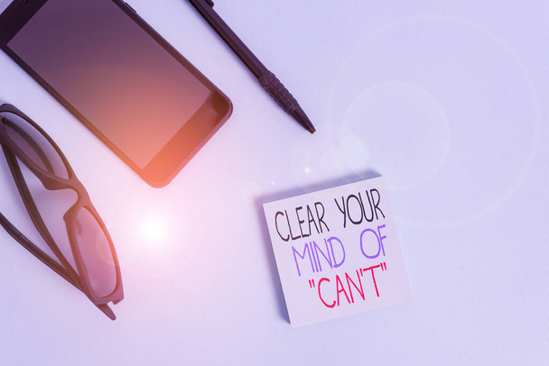 Handwriting text writing Clear Your Mind Of Can T. Concept meaning Have a positive attitude thinking motivation Eyeglasses colored sticky note smartphone cell pen cool pastel background. - Photo, Image