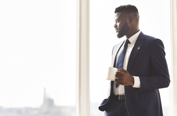 Giovane uomo d'affari di successo bere caffè in ufficio
 - Foto, immagini