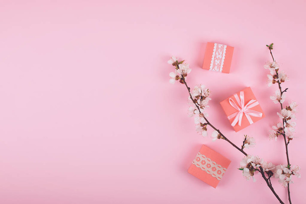 Flat lay with pink gift boxes and blooming cherry sakura flowers - Фото, изображение