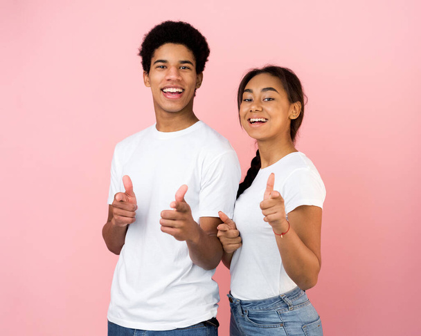 Cheerful teen couple pointing fingers at camera - Foto, afbeelding