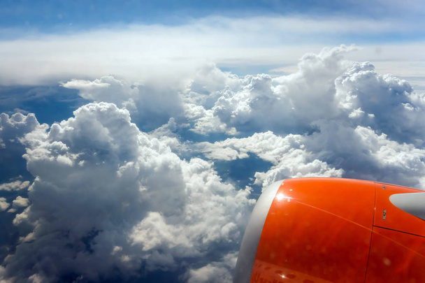 vliegtuig patrijspoort vliegende turbine boven witte wolken tropische - Foto, afbeelding
