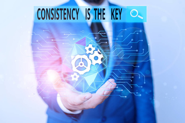 Word writing text Consistency Is The Key. Business concept for full Dedication to a Task a habit forming process Male human wear formal work suit presenting presentation using smart device. - Photo, Image