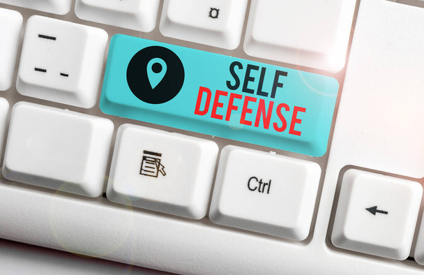 Text sign showing Self Defense. Conceptual photo the act of defending one s is demonstrating when physically attacked White pc keyboard with empty note paper above white background key copy space. - Photo, Image