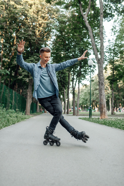 Катание на роликах, мужчина-подросток катается на одной ноге в парке. Катание на роликовых коньках, активный экстремальный спорт
 - Фото, изображение