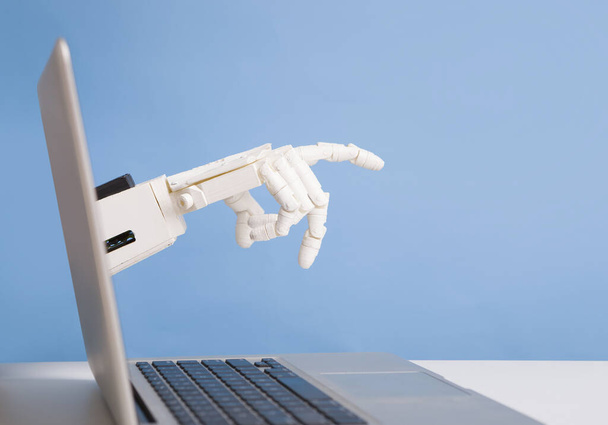 Робот протягивает руку с экрана ноутбука
 - Фото, изображение