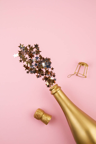 Top view Golden bottle of champagne and confettie. Party, new year, christmas, birthday celebration - 写真・画像
