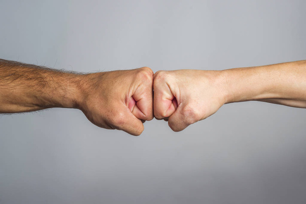 Zwei männliche Fäuste schlagen aufeinander ein. Konzept von Konfrontation, Wettbewerb usw. - Foto, Bild