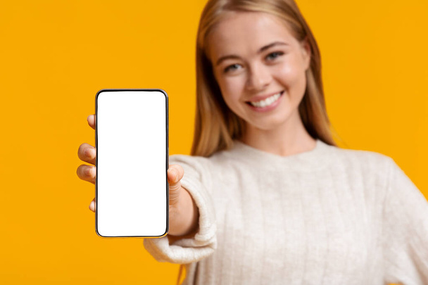 Söpö teini tyttö osoittaa älypuhelin tyhjä näyttö
 - Valokuva, kuva