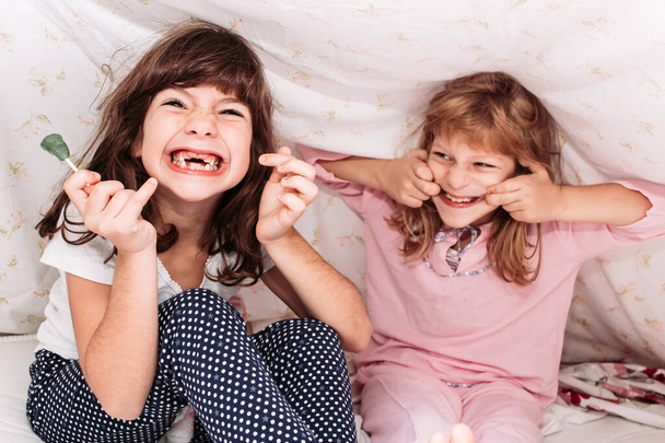 Close-up photo of little girls eating candy. Dental problems, teeth protection. - Foto, imagen
