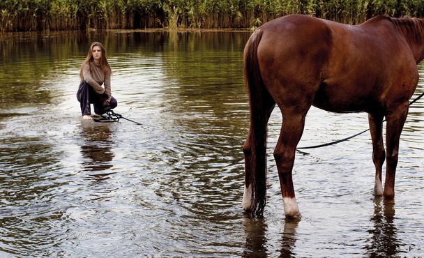 foto giovane impudente cavallerizza cammina un cavallo in uno stagno
 - Foto, immagini