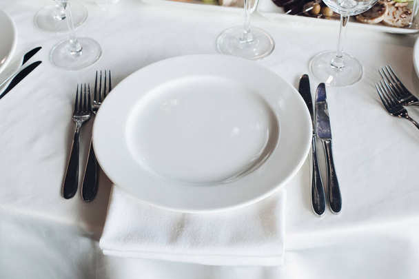 Крупним планом порожня подача білої великої пластини в оточенні вилки ножа, готової до їжі під високим кутом
 - Фото, зображення