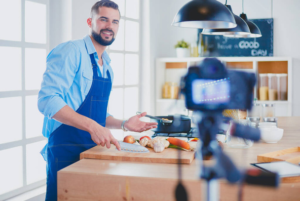 Чоловік тримає паперовий мішок повний продуктів на кухонному фоні. Концепція шопінгу та здорової їжі
 - Фото, зображення