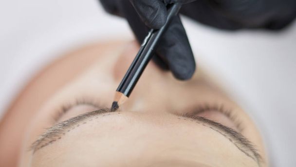 Косметолог наносит постоянный макияж на брови - Фото, изображение