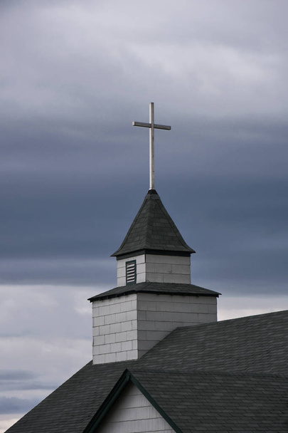 An image of an old church steeple and cross on a cloudy and dreary day. - Photo, Image