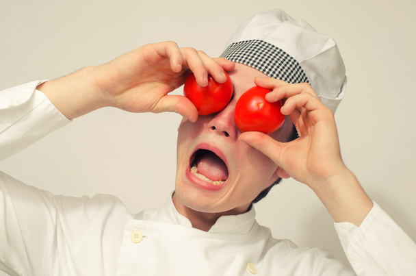 Funny chef playing with tomatoes and screaming - Foto, immagini