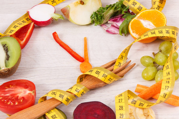 Tape measure with fruits and vegetables in shape of clock, healthy nutrition and slimming concept - Photo, Image
