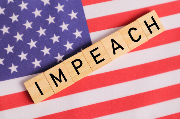 Concept of US politics, Impeachment showing with US flag with Impeach in wooden letters. - Photo, Image