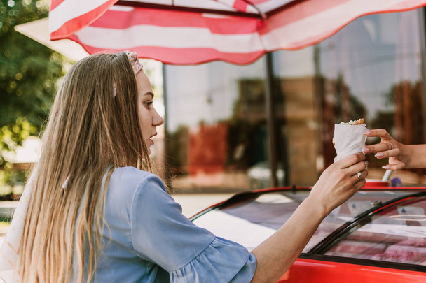 Menina da moda jovem compra sorvete em um cone de waffle no verão quente
  - Foto, Imagem