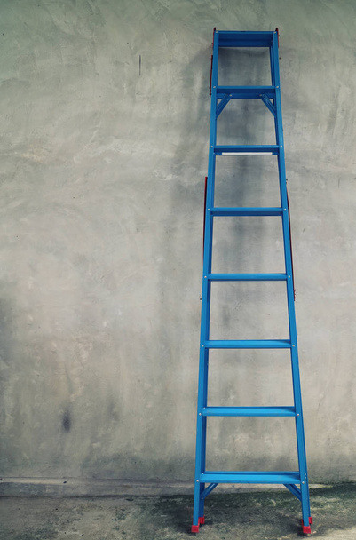 Blue aluminium step ladder that runs across the wall of the house - Foto, imagen
