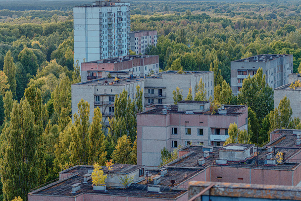 aerial view of the lost city of Pripyat. a lot of empty concrete floors overgrown with trees. Pripyat is empty after the evacuation for 33 years after the accident at the Chernobyl nuclear power plant - 写真・画像