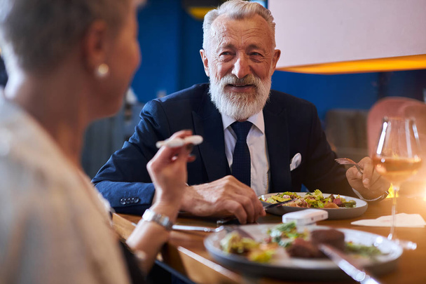 Senior caucasian couple have conversation over fining meal at restaurant - 写真・画像