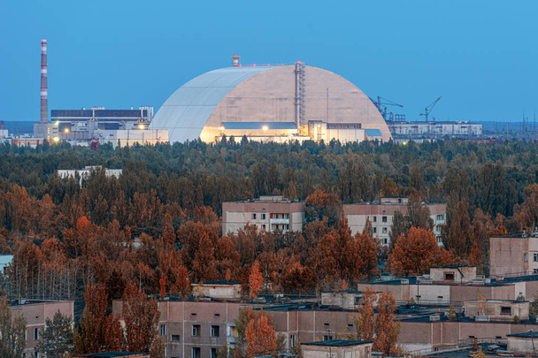 Вигляд нової захисної арки на вечірні відьмині вогні Чорнобильської АЕС через перспективу покинутого Прип'яті. Nsf - це новий саркофаг для безпечної деактивації. - Фото, зображення