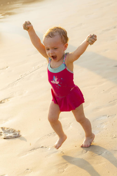 A little girl runs along the beach - Fotografie, Obrázek