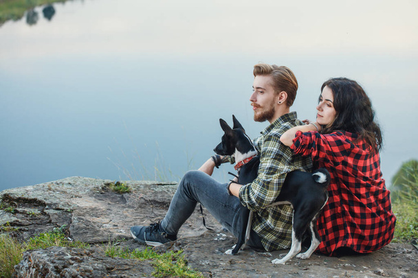 young couple and their adorable dog looking at the distance - Foto, Imagen