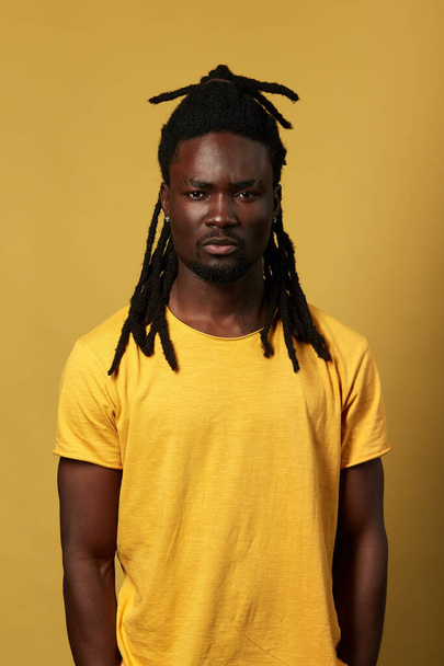 attractive african street guy in yellow T-shirt looking at the camera - Фото, зображення