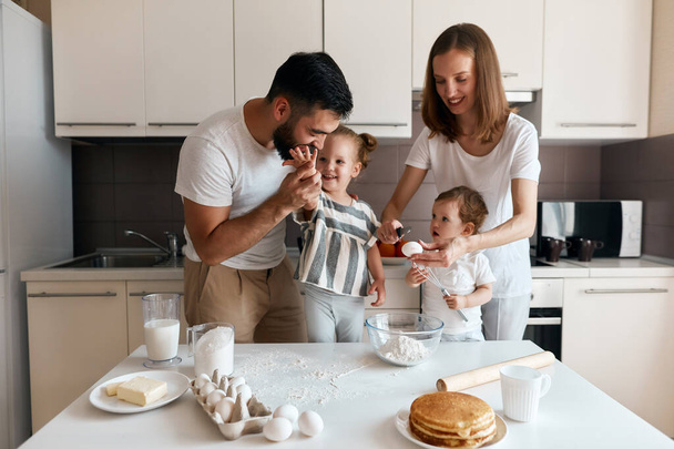 Adorable family cooking together in the kitchen - Foto, imagen
