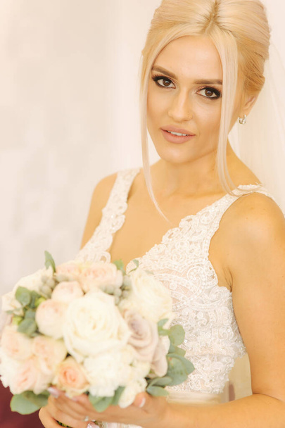 Portrait of gorgeous bride at home. Charming woman with bouquet. Morning of beautiful bride. Wedding day - Fotoğraf, Görsel